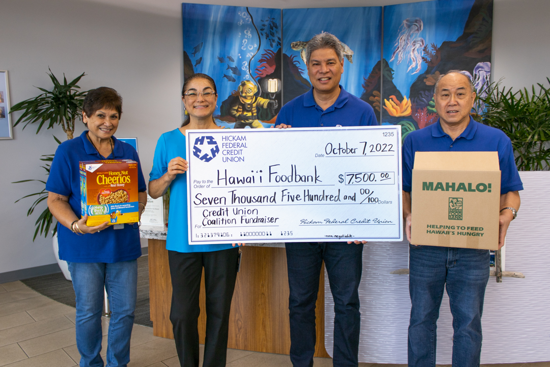 Hickam FCU President/CEO Scott Kaulukukui, SVP of Finance Delton Ho, and greeter Marsha Sarono pose with Hawaii Foodbank's VP and Chief Impact Officer Laura Kay Rand with a donation check