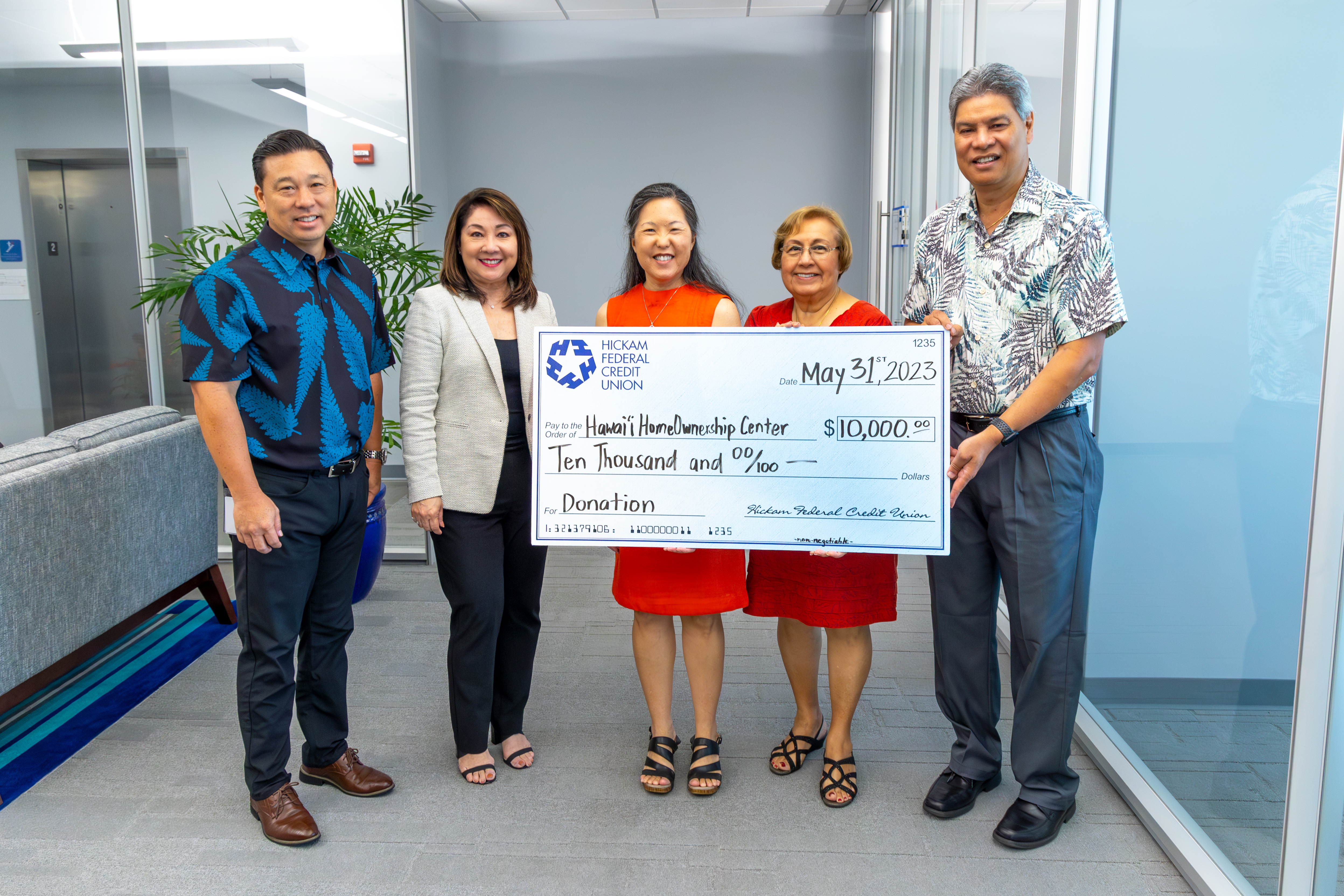 Hickam FCU Board Chair and Senior Management Team present a check to Reina from Hawaii HomeOwnership Center.