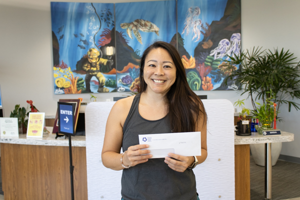 Stacey H. posing with her prize at the Pearl City Branch