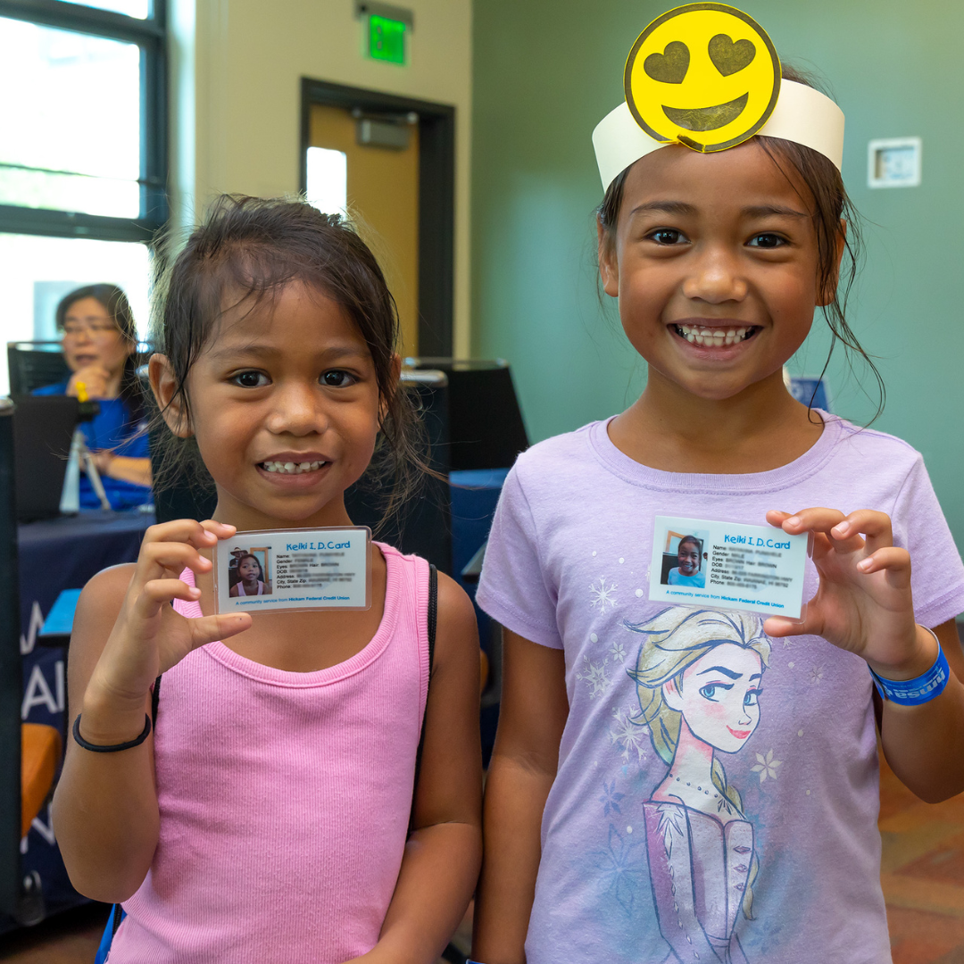 Two young girls pose with their Keiki IDs